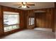 Bright living room featuring wood paneled walls, large window and view to adjacent room at 10759 Ogden St, Northglenn, CO 80233