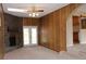 Spacious living room featuring a stone fireplace, French doors, and wood paneled walls at 10759 Ogden St, Northglenn, CO 80233
