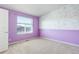 A cozy bedroom with a floral accent wall paired with lavender paint, featuring a bright window at 9180 E 52Nd Dr, Denver, CO 80238