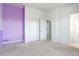 Spacious bedroom with modern closets, adjacent bathroom, and contrasting purple accent wall at 9180 E 52Nd Dr, Denver, CO 80238