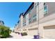 Modern townhouse exteriors feature neutral siding, attached garages, and well-kept landscaping under a clear blue sky at 9180 E 52Nd Dr, Denver, CO 80238