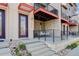Inviting home exterior with a charming front porch swing, brick facade, and stylish purple door at 9180 E 52Nd Dr, Denver, CO 80238