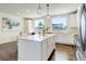 Modern kitchen with white cabinets, hardwood floors, island with barstools, and stainless steel appliances at 9180 E 52Nd Dr, Denver, CO 80238