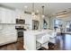 Modern kitchen with stainless steel appliances, center island with seating, white cabinets, open floor plan at 9180 E 52Nd Dr, Denver, CO 80238