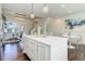 Open-concept kitchen with island, hardwood floors, white cabinets, with dining and living area at 9180 E 52Nd Dr, Denver, CO 80238