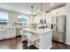 Bright kitchen boasts white cabinetry, stainless steel appliances, and a center island with bar seating at 9180 E 52Nd Dr, Denver, CO 80238