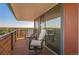 A covered balcony with comfortable seating and beautiful city and mountain views at 4570 E Yale Ave # 1004, Denver, CO 80222