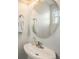 Small bathroom with a pedestal sink and round mirror at 12844 King St, Broomfield, CO 80020