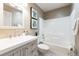 Cozy bathroom featuring a modern vanity, toilet, and a bathtub with a shower and tiled wall at 9811 Gatesbury Cir, Highlands Ranch, CO 80126