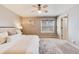 Comfortable bedroom with a ceiling fan, a light-toned rug and a window overlooking a tree filled neighborhood at 9811 Gatesbury Cir, Highlands Ranch, CO 80126