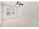 Bright bedroom with a large window, neutral walls and carpet, and a ceiling fan with light at 9811 Gatesbury Cir, Highlands Ranch, CO 80126