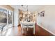 Dining room with hardwood floors, light walls, access to patio, chandelier, and view into the kitchen at 9811 Gatesbury Cir, Highlands Ranch, CO 80126