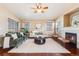 Bright living room featuring a fireplace, neutral walls, ceiling fan, hardwood floors, and ample natural light at 9811 Gatesbury Cir, Highlands Ranch, CO 80126