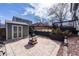 A concrete patio area featuring a charming fire pit, storage shed, and a tiered garden bed leading to a wooden deck at 9811 Gatesbury Cir, Highlands Ranch, CO 80126