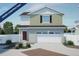 Two-story home with a white garage door and siding, with sage green horizontal siding on the second story at 22073 E 38Th Pl, Aurora, CO 80019