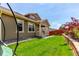 Side view of a well-manicured lawn and backyard with a covered porch and beautiful garden at 16321 Clayton St, Thornton, CO 80602