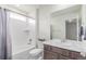 Bright bathroom features tub, shower, marble vanity, and decorative mirror at 16321 Clayton St, Thornton, CO 80602