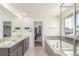 Bright bathroom features a double sink vanity, soaking tub, and separate shower at 16321 Clayton St, Thornton, CO 80602