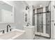 Modern bathroom with double vanity and shower with decorative tiles at 16321 Clayton St, Thornton, CO 80602