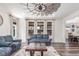 Bright living room featuring large windows, wood floors, and stylish furniture at 16321 Clayton St, Thornton, CO 80602