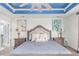 Inviting primary bedroom features a decorative tray ceiling, matching lamps, and decor at 16321 Clayton St, Thornton, CO 80602