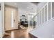 Welcoming entryway flows into a cozy living room with modern decor, wood floors, and staircase at 7203 W Pacific Ave, Lakewood, CO 80227