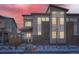 Modern home exterior featuring gray siding, brick accents, and large windows with a dusk sky backdrop at 7203 W Pacific Ave, Lakewood, CO 80227