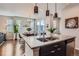 Open-concept kitchen area featuring an island with a sink, dark cabinetry, and a view to dining area at 7203 W Pacific Ave, Lakewood, CO 80227