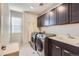 Well equipped laundry room with modern appliances and storage cabinets at 7203 W Pacific Ave, Lakewood, CO 80227