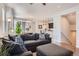 Comfortable living room features a large sectional sofa, wood floors, and a view into the dining area and kitchen at 7203 W Pacific Ave, Lakewood, CO 80227