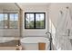 Luxurious bathroom with soaking tub, walk-in shower, and large window at 1295 S Garfield St, Denver, CO 80210