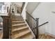 Carpeted staircase with wooden railings, leading to the upper level of the home at 8872 E 47Th Ave, Denver, CO 80238