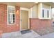 Inviting front entrance with brick accents, a light, and a beige-painted front door at 9032 Gale Blvd # 1, Thornton, CO 80260