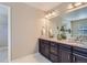 Bathroom vanity with double sinks, dark cabinets, granite countertops and tile flooring at 4545 S Monaco St # 436, Denver, CO 80237