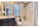 Well-lit bathroom featuring a vanity, toilet, and bathtub-shower combination with white tiling at 4545 S Monaco St # 436, Denver, CO 80237