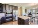 Well-equipped kitchen with dark cabinetry, stainless steel appliances, a center island, and view to the dining area at 4545 S Monaco St # 436, Denver, CO 80237