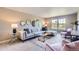 Bright living room with a plush sectional sofa, decorative mirrors, and large windows offering natural light at 4545 S Monaco St # 436, Denver, CO 80237