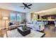 Inviting living room with stylish seating, a modern ceiling fan, and large windows providing natural light at 4545 S Monaco St # 436, Denver, CO 80237