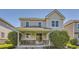 Back exterior view featuring a covered patio, lush greenery, and seating area at 4545 S Monaco St, Denver, CO 80237