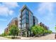 Modern multi-story building with ample windows and balconies, complemented by lush greenery and vibrant streetscape at 4545 S Monaco St, Denver, CO 80237