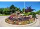 Beautiful community entrance featuring a stone wall adorned with colorful flowers and well-maintained landscaping at 4545 S Monaco St, Denver, CO 80237