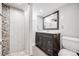 Modern bathroom featuring a tiled shower, dark vanity, and contemporary fixtures at 7350 Dale Ct, Westminster, CO 80030