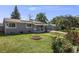 Single-story home with solar panels and landscaped front yard featuring mature trees and flowers at 7350 Dale Ct, Westminster, CO 80030