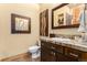 Bathroom with wood vanity, tile countertop, decorative mirror, and a tub-shower at 12161 S Leaning Pine Ct, Parker, CO 80134