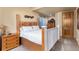 Bedroom with wooden bed frame, white bedding, and natural wood nightstand at 12161 S Leaning Pine Ct, Parker, CO 80134
