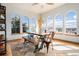 Elegant dining area featuring a rustic wood table, unique chairs, and arched windows with scenic views at 12161 S Leaning Pine Ct, Parker, CO 80134