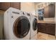 Modern laundry room with front-loading washer and dryer, ample counter space, and storage cabinets at 12161 S Leaning Pine Ct, Parker, CO 80134