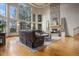 Bright and airy living room with large windows, a stone fireplace, and hardwood flooring at 12161 S Leaning Pine Ct, Parker, CO 80134