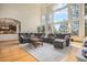 Bright living room boasts large windows, hardwood floors, and comfortable gray sectional seating at 12161 S Leaning Pine Ct, Parker, CO 80134