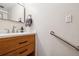 Bathroom featuring white countertops, wood cabinets, safety bar, and modern fixtures at 2557 S Dover St # 30, Lakewood, CO 80227